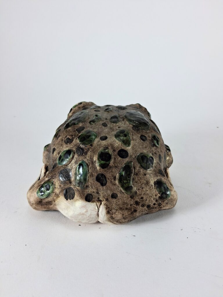 The back of the sculpture, showing even more green and black spots. At the base of the back there is a small butt with a little crack.